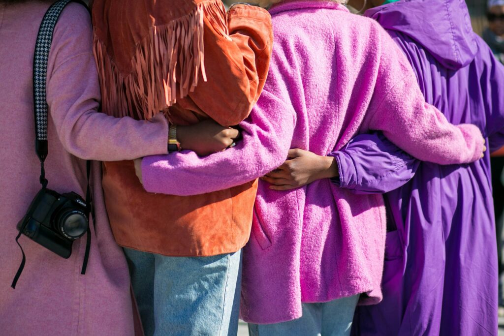 Shot of the backs of four women holding each other