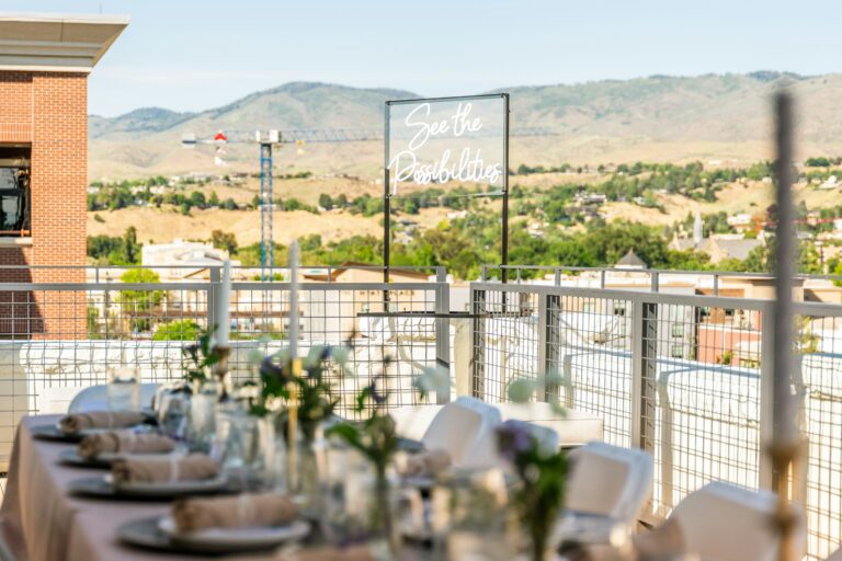 Table set with plates, silverware, and glasses for a corporate event on a rooftop