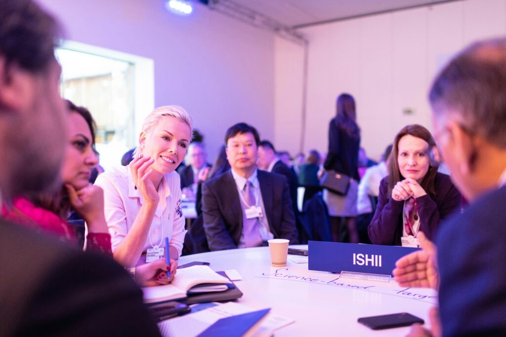 Men and women seated at a table at a corporate event talking