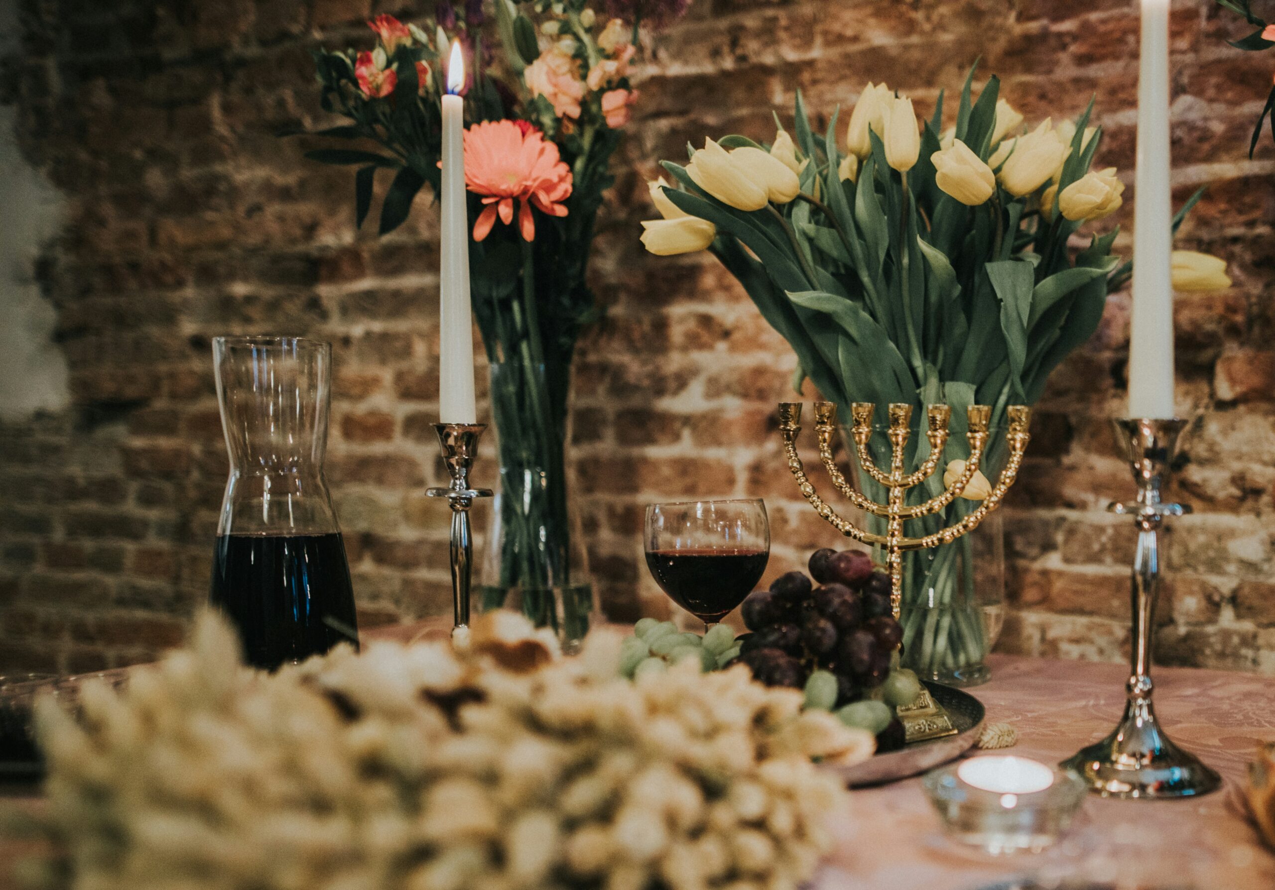 Menorah and wine on a table with flowers